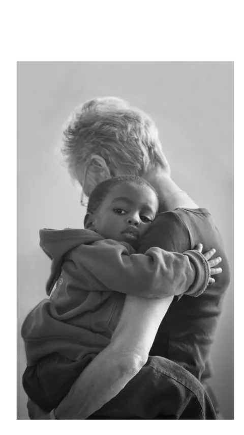 Mãe abraçando o filho, em foto preto e branco